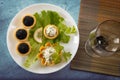 Tartlets filled with red and black caviar and cheese and dill salad on white plate against blue wooden background Royalty Free Stock Photo