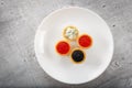 Tartlets filled with red and black caviar and cheese and dill salad on white plate against silver wooden background Royalty Free Stock Photo