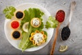 Tartlets filled with red and black caviar and cheese and dill salad on white plate against silver wooden background Royalty Free Stock Photo