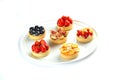 Tartlets with fruits and berries in a plate on an isolated white background Royalty Free Stock Photo