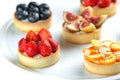 Tartlets with fruits and berries in a plate close-up on an isolated white background Royalty Free Stock Photo