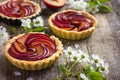 Tartlets with plum on wooden background