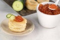 Tartlets, red caviar, cucumber on a white table. Recipe for making an appetizer with red caviar. Cooking process. Royalty Free Stock Photo