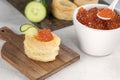 Tartlets, red caviar, cucumber on a white table. Recipe for making an appetizer with red caviar. Cooking process Royalty Free Stock Photo