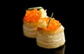 Tartlets with red caviar isolated on black background, close up. Gourmet food close up, appetizer