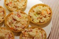 Tartlets with snack on white plate