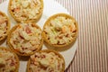 Tartlets with snack on white plate