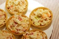 Tartlets with snack on white plate