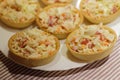 Tartlets with snack on white plate