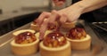 Tartlets on the table of a professional confectioner are decorated with apple-jelly