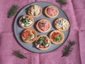 Tartlets with various salads on a large ceramic dish.