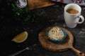 Tartlets with whipped cream, with lemon, coffee americano, wooden basket and green leaves