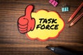 Task Force. Sticky note with text on wooden texture office table