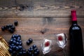 Taste red wine. Bottle of red wine, glass and black grape on dark wooden background top view copyspace Royalty Free Stock Photo