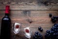 Taste red wine. Bottle of red wine, glass and black grape on dark wooden background top view copyspace Royalty Free Stock Photo