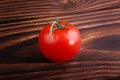 A tasteful red tomato on a brown background. Natural organic vegetables full of nutrients. Healthy vegan diet.