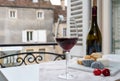 Tasting of burgundy red wine from grand cru pinot noir vineyards with french goat cheeses and view on old town street in Burgundy