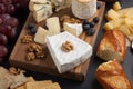 Tasting cheese dish on a dark stone plate. Food for wine and romantic date, cheese delicatessen on a black concrete background Royalty Free Stock Photo