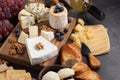 Tasting cheese dish on a dark stone plate. Food for wine and romantic date, cheese delicatessen on a black concrete background Royalty Free Stock Photo