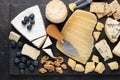 Tasting cheese dish on a dark stone plate. Food for wine and romantic date, cheese delicatessen on a black concrete background. To