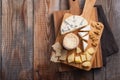 Tasting cheese dish on a wooden plate. Food for wine and romantic, cheese delicatessen on a wooden rustic table. Top view with cop Royalty Free Stock Photo