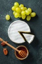 Tasting cheese dish on a wooden plate. Food for wine and romantic date  cheese delicatessen on a black concrete background. Top Royalty Free Stock Photo