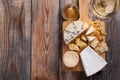 Tasting cheese dish on a wooden plate. Food for wine and romantic, cheese delicatessen on a wooden rustic table. Top view with cop Royalty Free Stock Photo