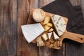 Tasting cheese dish on a wooden plate. Food for wine and romantic, cheese delicatessen on a wooden rustic table. Top view with cop Royalty Free Stock Photo