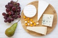 Tasting cheese with fruits on a white wooden background. Food for wine, top view. Flat lay.
