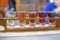 tasting of colorful fruit and berry liqueurs on a wooden stand on a craft background