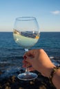 Tasting of glass of cold white wine on outdoor terrace with sea Royalty Free Stock Photo