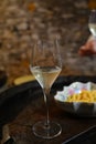 New year party, small bubbles of brut champagne cava or prosecco wine in tulip glasses with garland lights on background