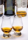 Tasting of whiskey, tulip-shaped tasting glasses with dram of Scotch single malt or blended whisky on white table