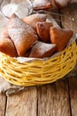 Tasty African Mandazi with powdered sugar close-up in a basket.