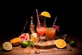 tasty alcohol cocktails on wooden board with fruits