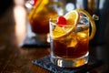 Tasty alcoholic old fashioned cocktail with orange slice, cherry, and lemon peel garnish Royalty Free Stock Photo