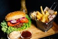 Tasty american food - beef burger with grilled meat and mayo served with fries, coleslaw and beer