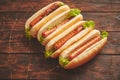 Tasty american hot dogs assorted in row. Placed on wooden table