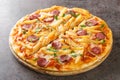 Tasty Americana Pizza with french fries, wurstel, cheese, tomato sauce and herbs close-up on a wooden board. Horizontal Royalty Free Stock Photo