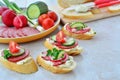 Tasty appetizers with cream cheese, salami and vegetables