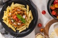 Tasty appetizing classic italian penne pasta with vegetarian lentil bolognese sauce, cheese parmesan and basil on plate on light Royalty Free Stock Photo