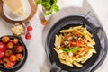 Tasty appetizing classic italian penne pasta with vegetarian lentil bolognese sauce, cheese parmesan and basil on plate on light Royalty Free Stock Photo