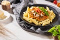 Tasty appetizing classic italian penne pasta with vegetarian lentil bolognese sauce, cheese parmesan and basil on plate on light Royalty Free Stock Photo