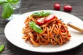 Tasty appetizing classic italian spaghetti pasta with tomato sauce, fresh cherry tomatoes and basil on ceramic plate. Royalty Free Stock Photo