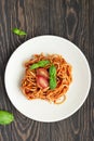 Tasty appetizing classic italian spaghetti pasta with tomato sauce, fresh cherry tomatoes and basil on ceramic plate. Royalty Free Stock Photo