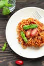 Tasty appetizing classic italian spaghetti pasta with tomato sauce, fresh cherry tomatoes and basil on ceramic plate. Royalty Free Stock Photo