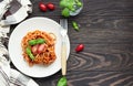 Tasty appetizing classic italian spaghetti pasta with tomato sauce, fresh cherry tomatoes and basil on ceramic plate. Royalty Free Stock Photo