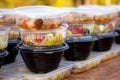 Tasty appetizing food in closed plastic transparent, black containers on table Royalty Free Stock Photo