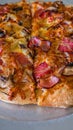 Tasty and appetizing Italian pizza with bacon, onion, mushrooms and red chilli Royalty Free Stock Photo