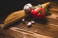 Tasty appetizing italian spaghetti pasta ingredients for kitchen cuisine with tomato, garlic and basil on wooden brown table. Food Royalty Free Stock Photo